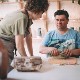 Na zdjęciu uczestnik ceramicznych warsztatów - Pan Marek - wykonuje z gliny przedmiot, który następnie zostanie wysuszony, pomalowany i wypalony w piecu, tak by nadawał się do codziennego użytkowania.